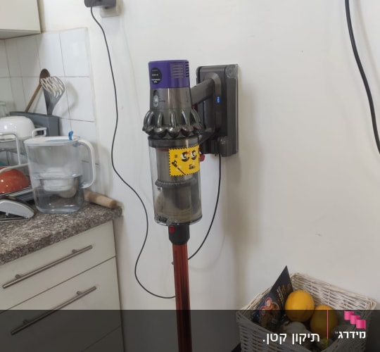 שואב אבק אלחוטי תלוי על הקיר בטעינה
